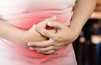 woman holding her stomach in pain